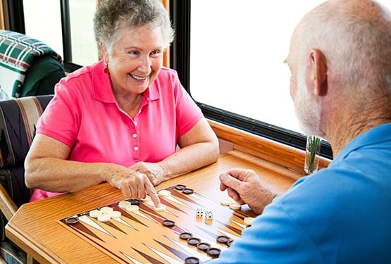 Another senior couple enjoying a game of dominos together during their Respite stay at our senior living community here at Grand Villa of Clearwater in Florida