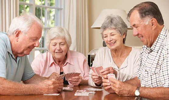 Friends in the community playing cards at the table.