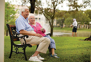 Happy couple sitting on bench at Rittenhouse Village At Valparaiso