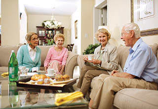 Friends sitting on couch talking at Rittenhouse Village At Michigan City