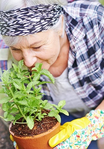 One of our happy residents here at Greenridge Place tending to her flowers