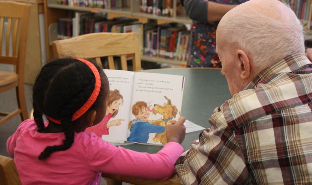child reading to senior resident