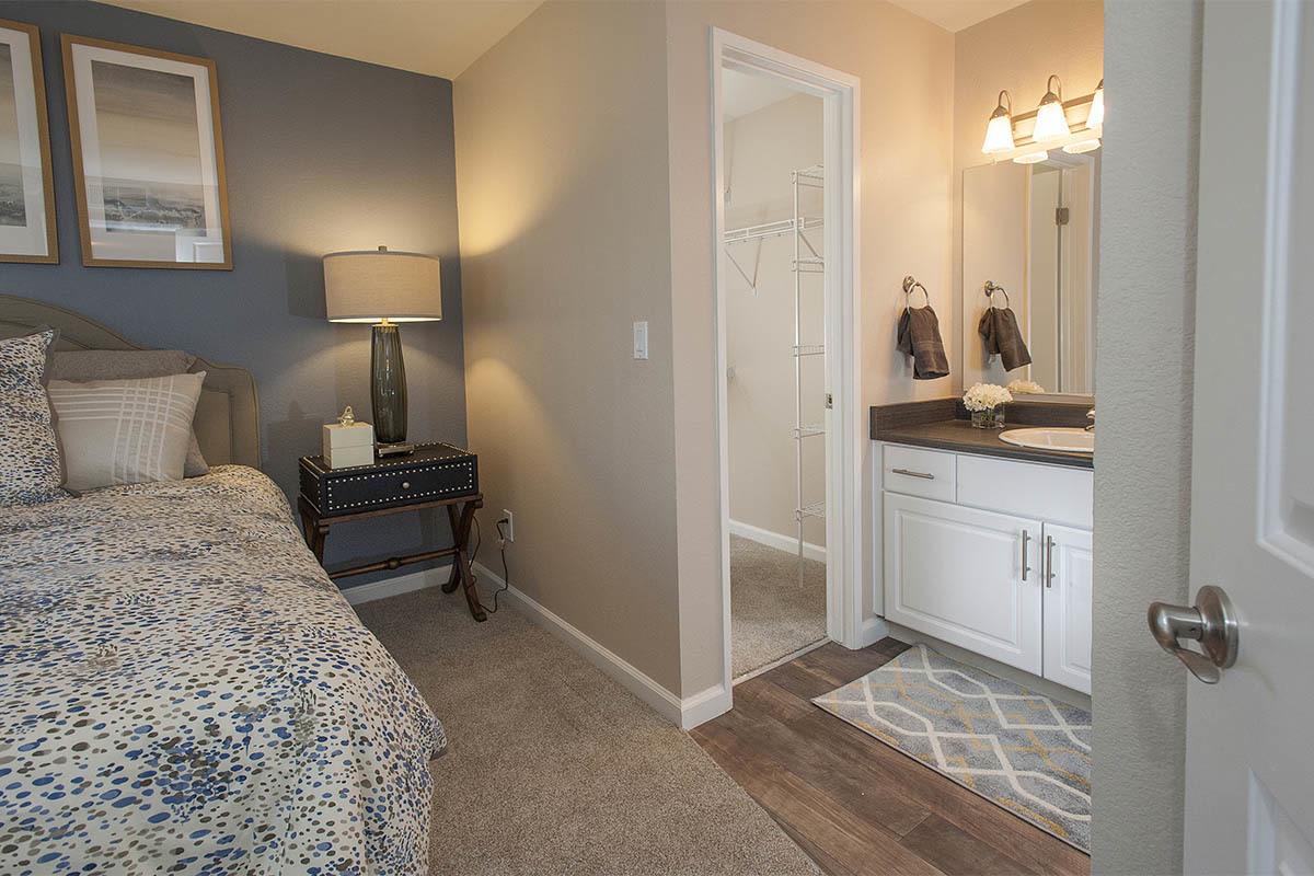 Cozy master bedroom with ensuite bathroom at Mill Springs Park Apartment Homes in Livermore, California