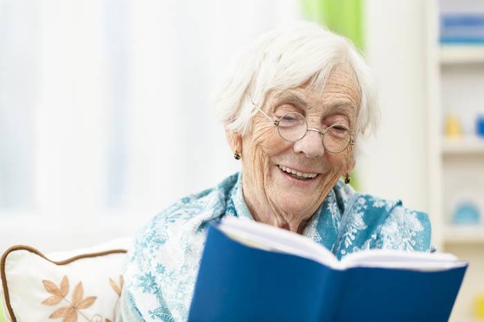 Resident enjoying a book at The Terraces at Park Marino in Pasadena