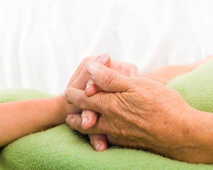 Parkinson's care patient holding hands at Skyline Place Senior Living