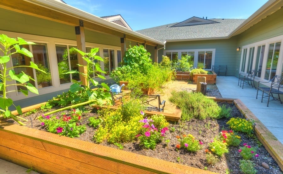 A courtyard with a garden at The Quarry Senior Living in Vancouver, Washington