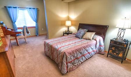 Bed and desk at The Quarry Senior Living