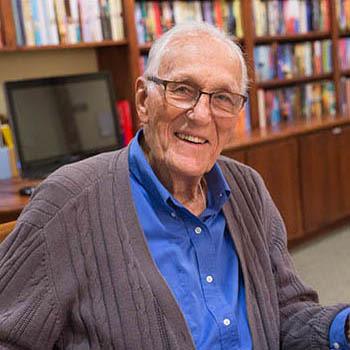 Senior man enjoying time in the library at Orchard Pointe at Terrazza