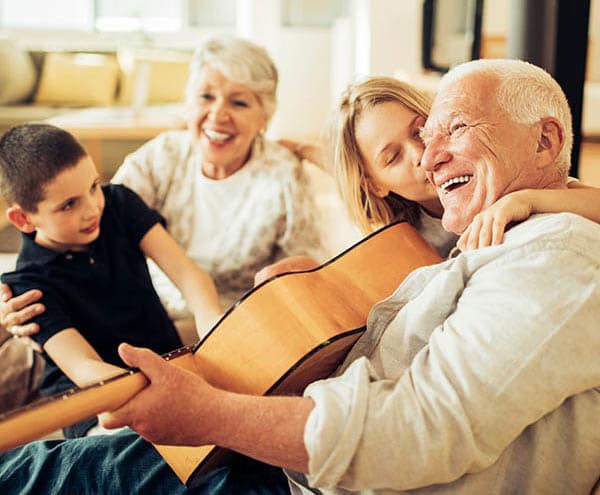 Senior playing guitar at Ridgeline Management Company