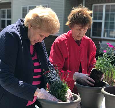 Senior living residents gardening at Waltonwood Lake Boone 