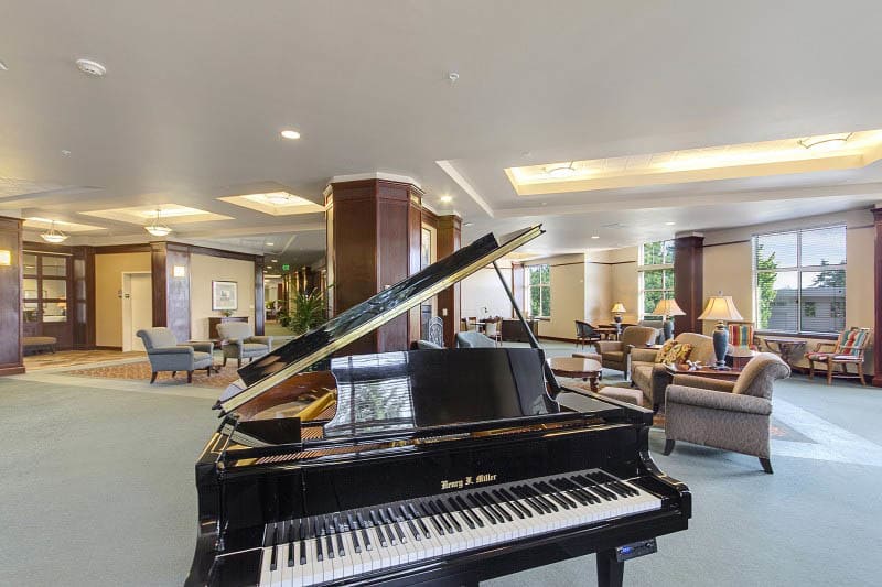 Common room with a piano at Merrill Gardens at Tacoma in Tacoma, Washington. 