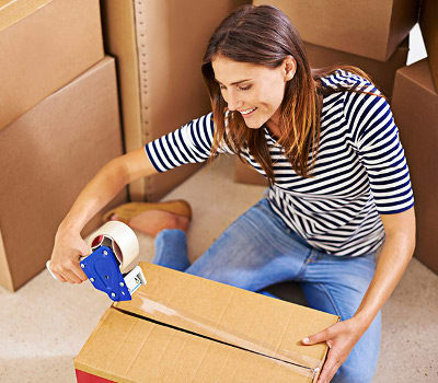 A woman taping up a box near Storaway Self Storage in Nashville, Tennessee