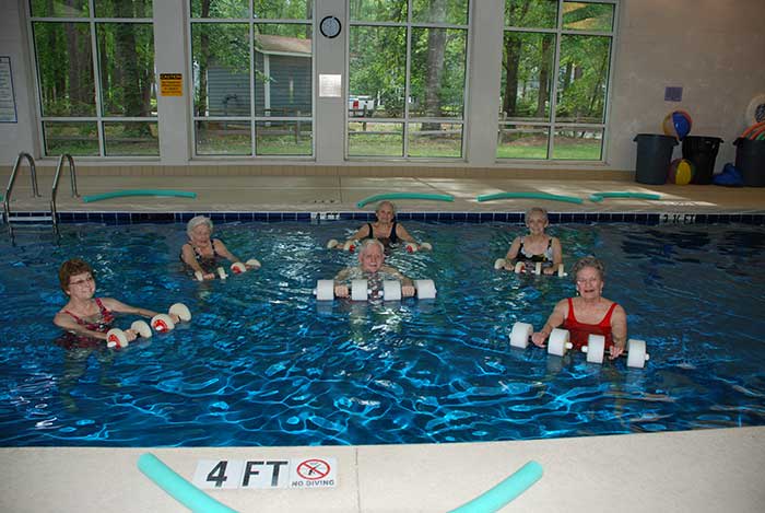 Residents at The Village at Summerville engage in a pool party together.
