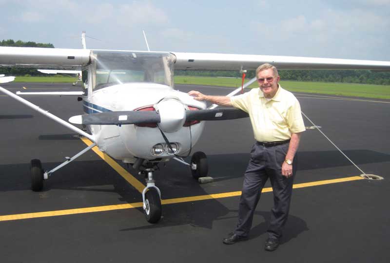 Mr. Glisson standing with an airplane on the tarmac in Summerville