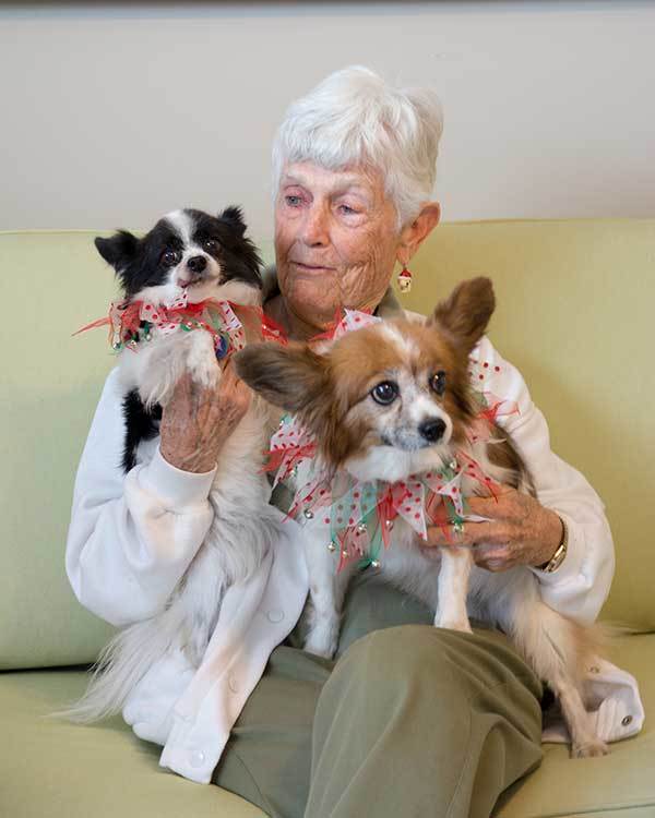 Assisted living resident loves her pet doggies at RobinBrooke Senior Living