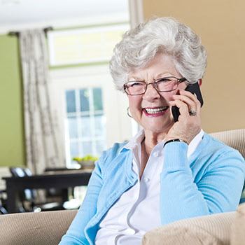 A elderly lady talking on the phone about RobinBrooke Senior Living