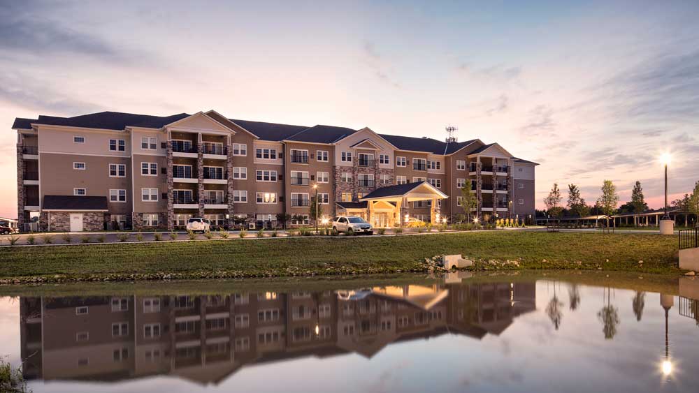 frontal view of the campus and large pond in front of Oxford Villa Active Senior Apartments in Wichita, Kansas