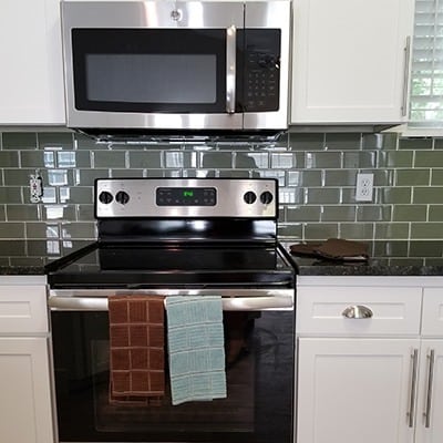 Upgraded kitchen with black appliances and custom tile backsplash at Bradley Park Apartments