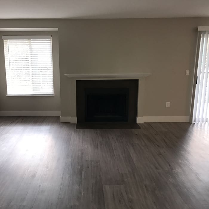 Fireplace and hardwood floors in model home at Hamptons Apartments
