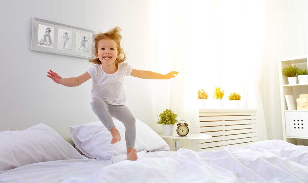 Child jumping on the bed at Columbia Commons