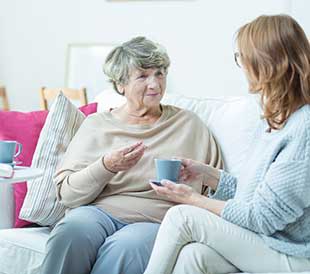 A resident and caregiver enjoy tea together at HarborChase of Beavercreek in Beavercreek, Ohio