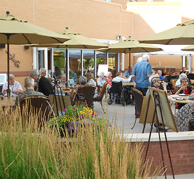 Residents on the patio sharing another delectable, fresh meal together at Clermont Park