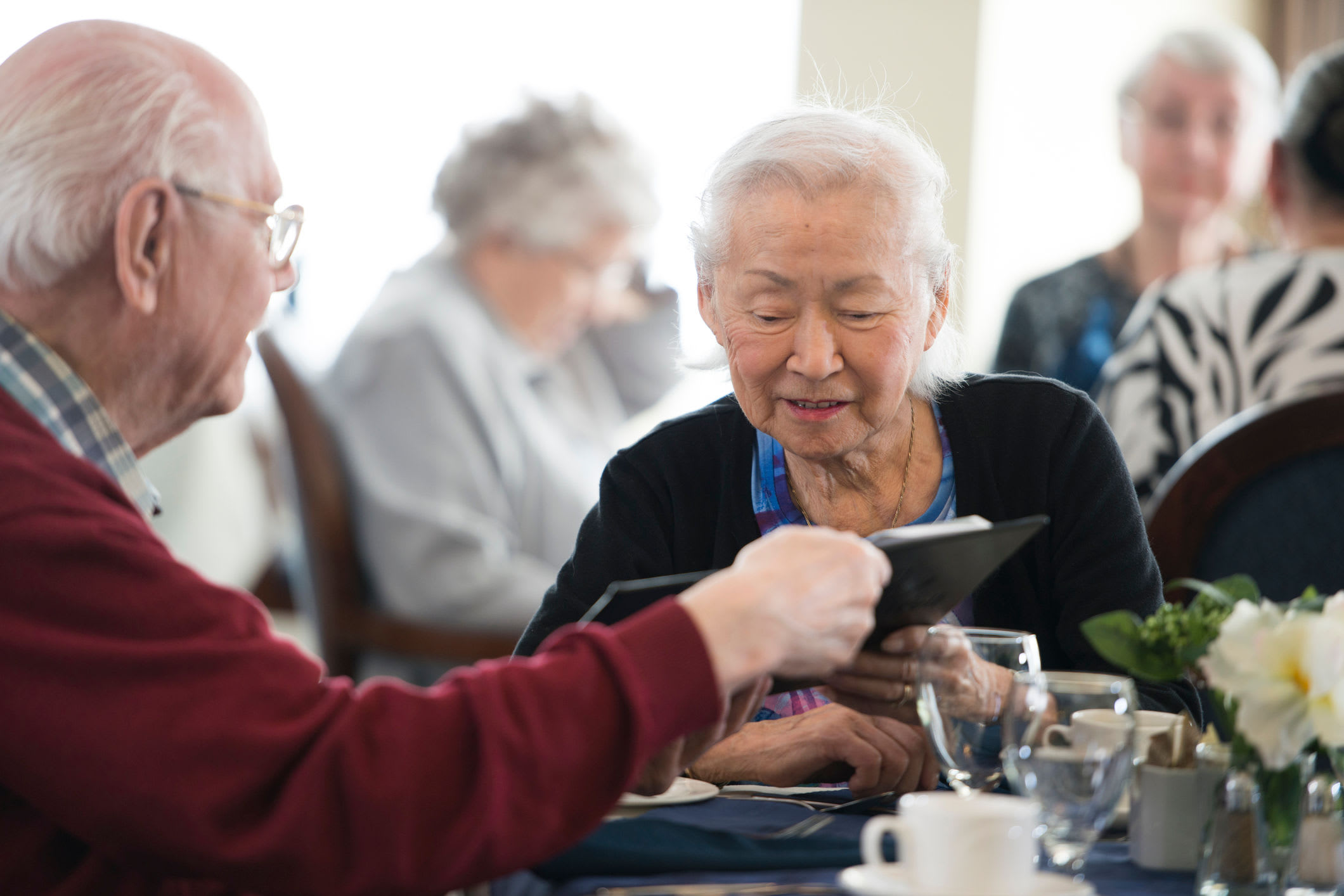 Elderly couple reading the Comfort Residence menu for dinner.