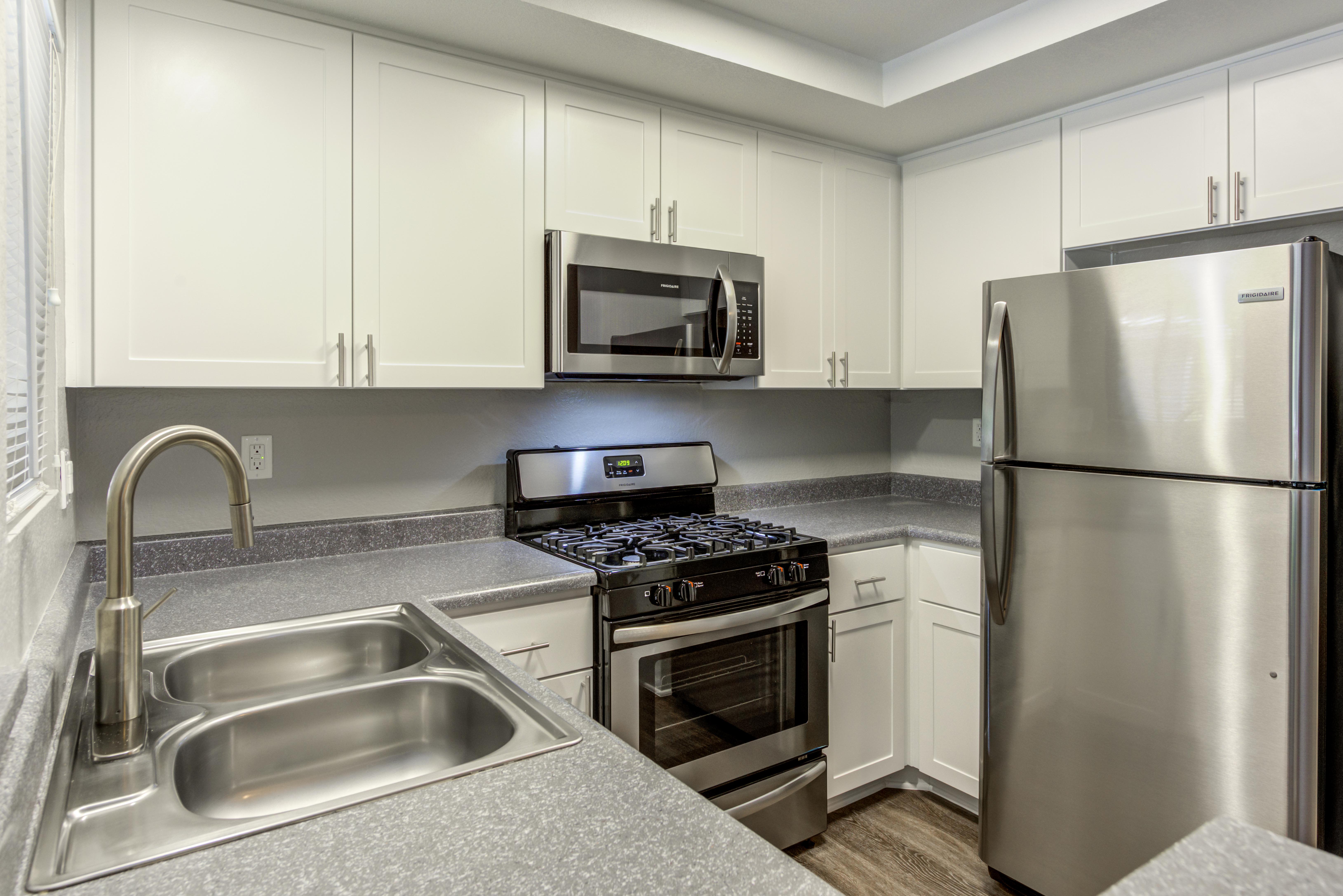 White Renovated Kitchen with stainless steel appliances at Village Oaks in Chino Hills,