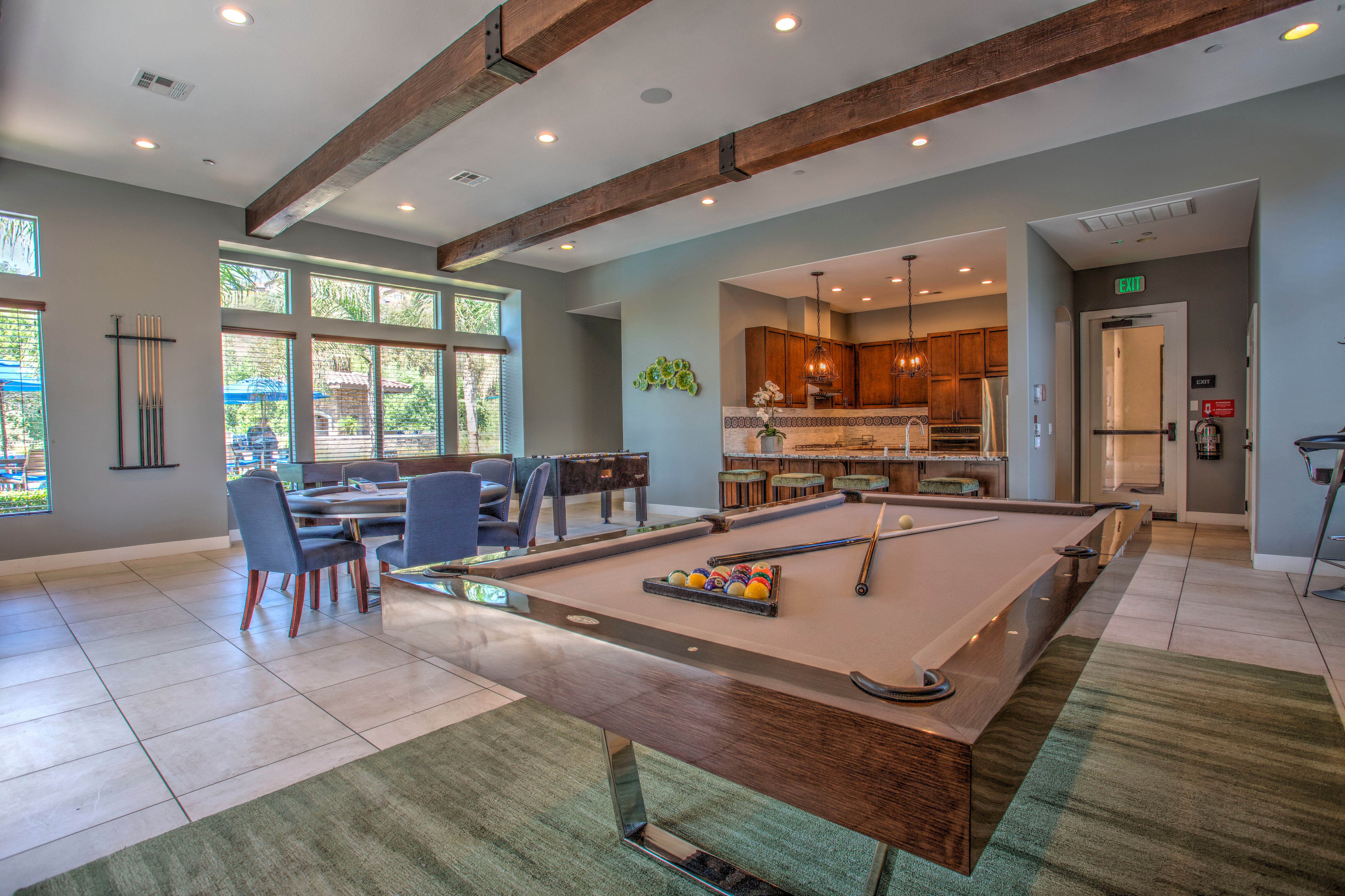 A commons area with a bar, pool, cardtable, foosball, and shuffleboard at Palisades Sierra Del Oro in Corona, California