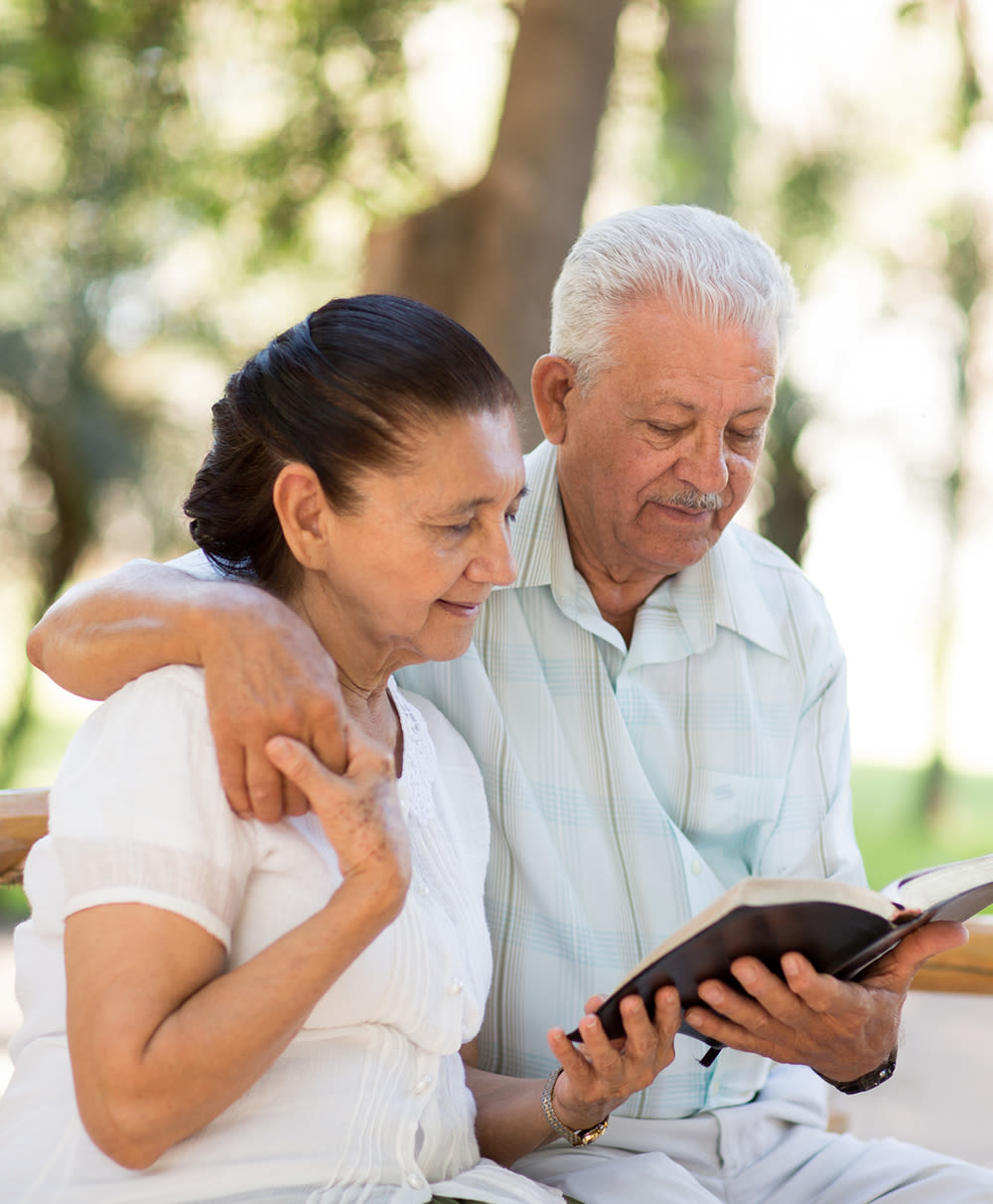 Seniors reading a book together at The Inn at Greenwood Village in Greenwood Village, Colorado