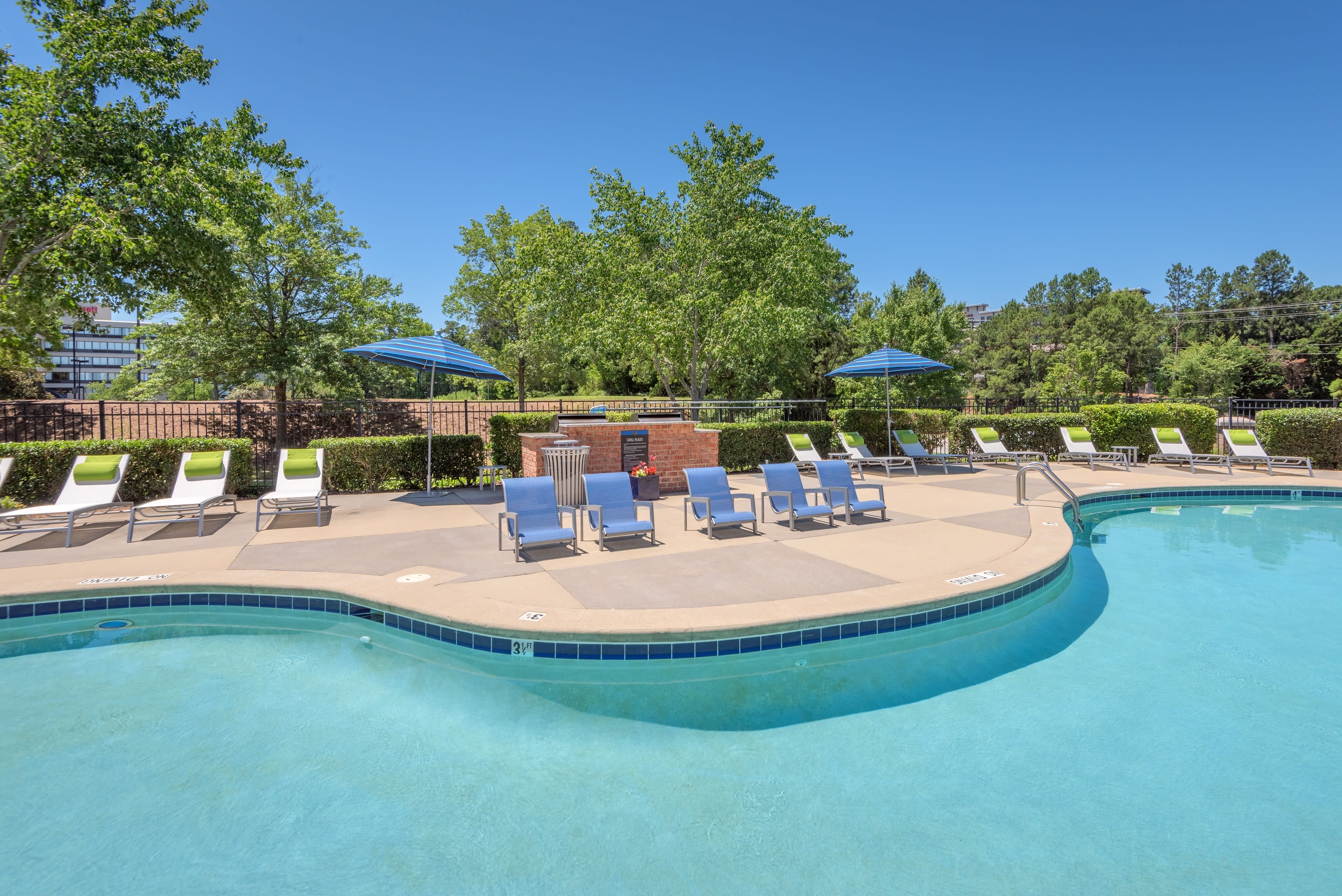 Resort-style swimming pool with plenty of chaise lounge chairs nearby at 200 East in Durham, North Carolina