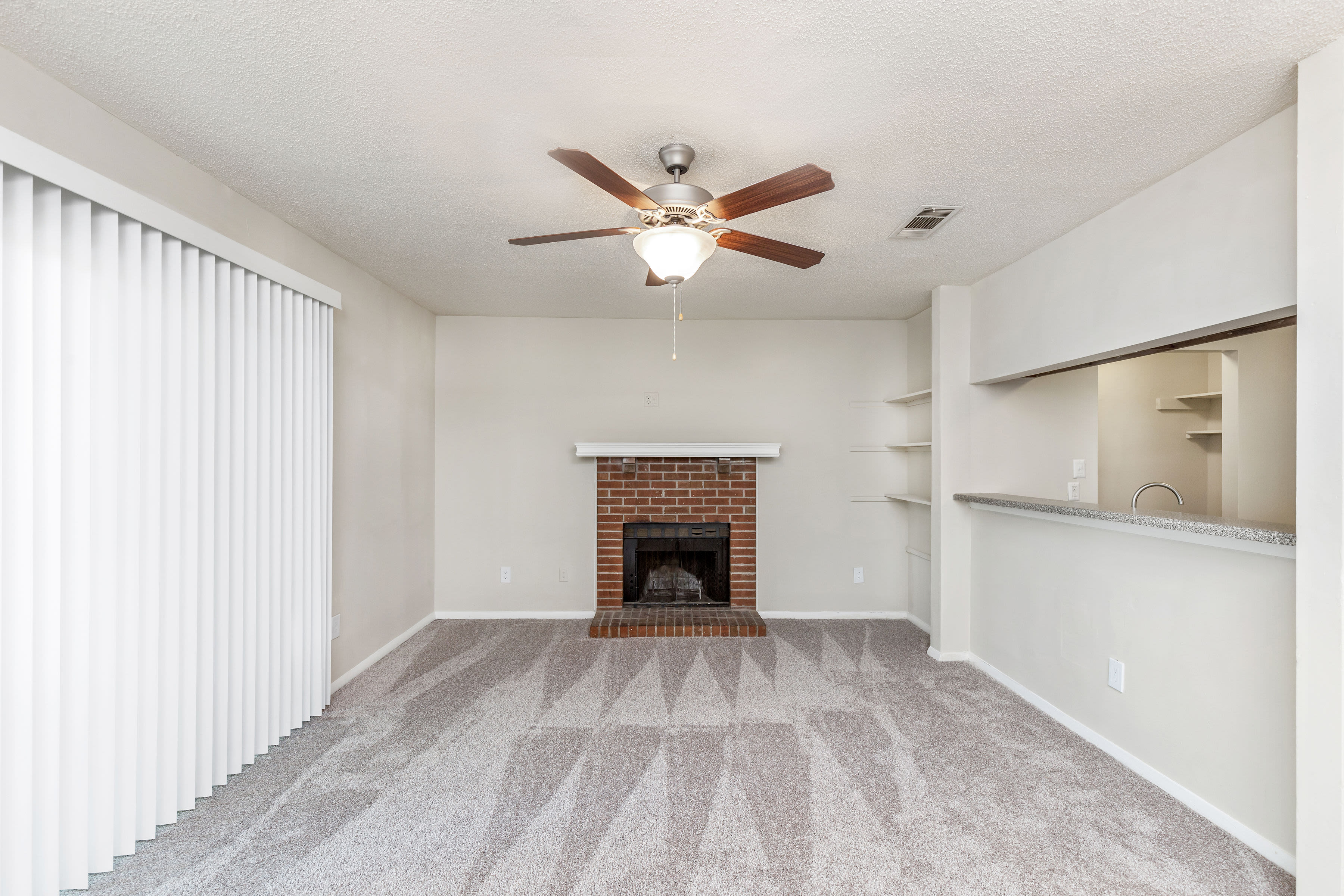 Living room with carpeting and ceiling fan at Austell Village Apartment Homes in Austell, Georgia