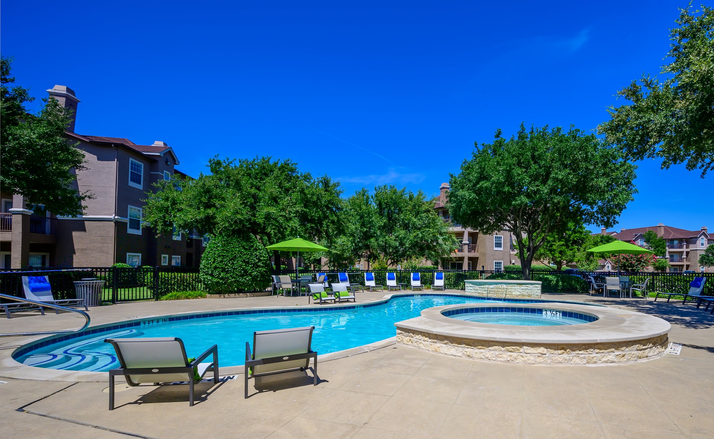 Resort style pool with lounge chairs at The View at Lakeside in Lewisville, Texas