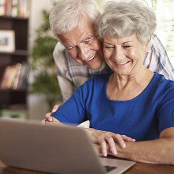 Senior couple having fun with laptop at Azpira Place of Breton