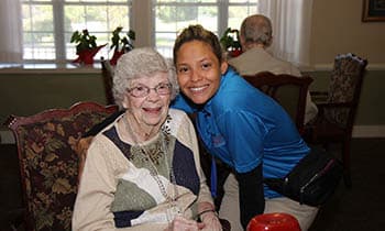 Caregiver and resident smiling for a photo at West Fork Village in Irving, Texas