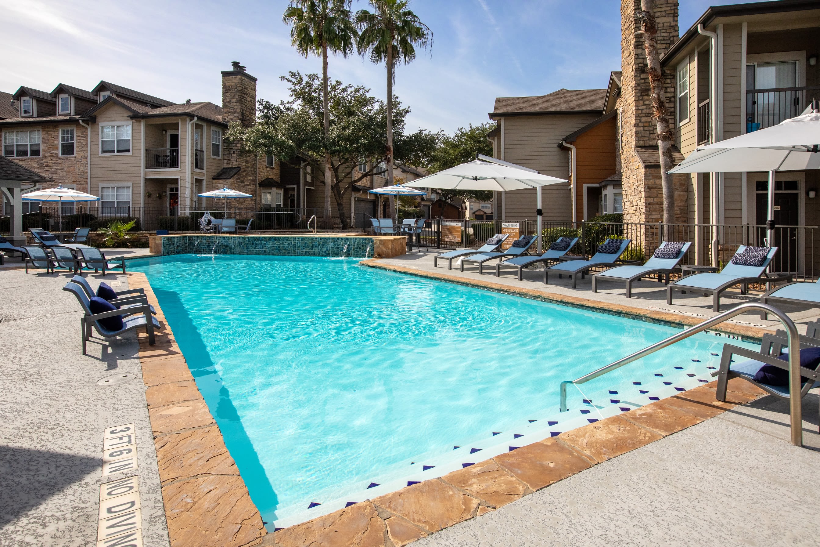 Lounge chairs alongside outdoor pool at Artisan at Lake Wyndemere in The Woodlands, Texas