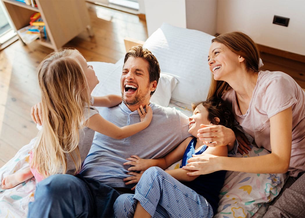 Happy family laughing together at Regency & Victor Villas Apartments in Victor, New York