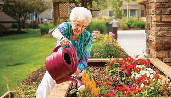 A resident watering flowers at The Heritage at Fountain Point in Norfolk, Nebraska