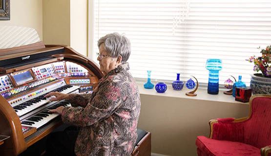 A resident playing a piano at The Heritage at Fountain Point in Norfolk, Nebraska