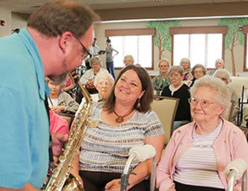 A guest playing the saxophone for residents at The Heritage at Fountain Point in Norfolk, Nebraska