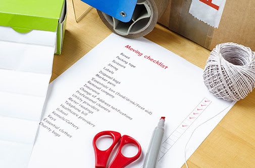 Packing list, scissors and a marker next to a box ready to be packed and stored at Fremont Heated Storage in Seattle, Washington