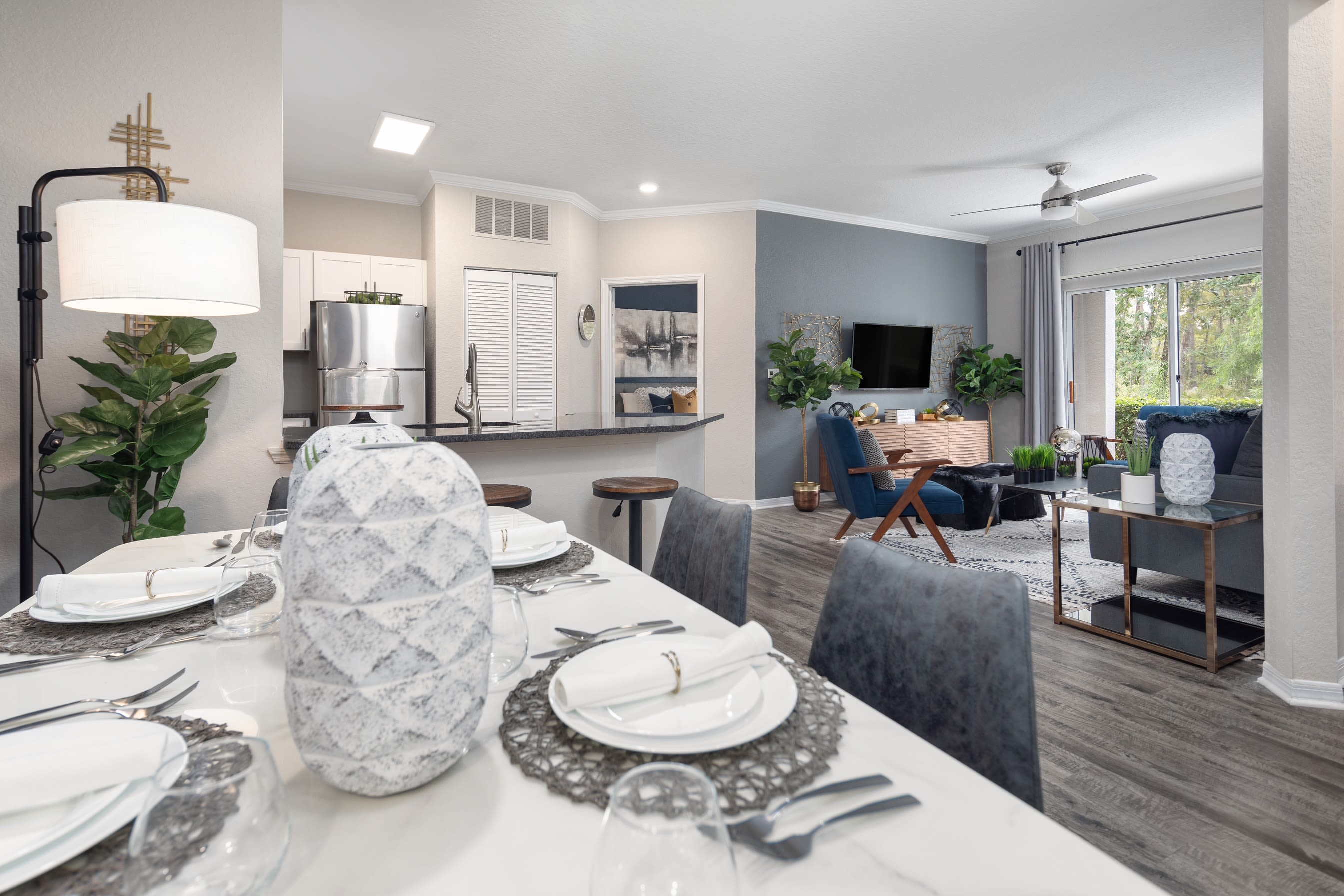 View of the kitchen and living areas from an open-concept model apartment's dining area at Mezza in Jacksonville, Florida