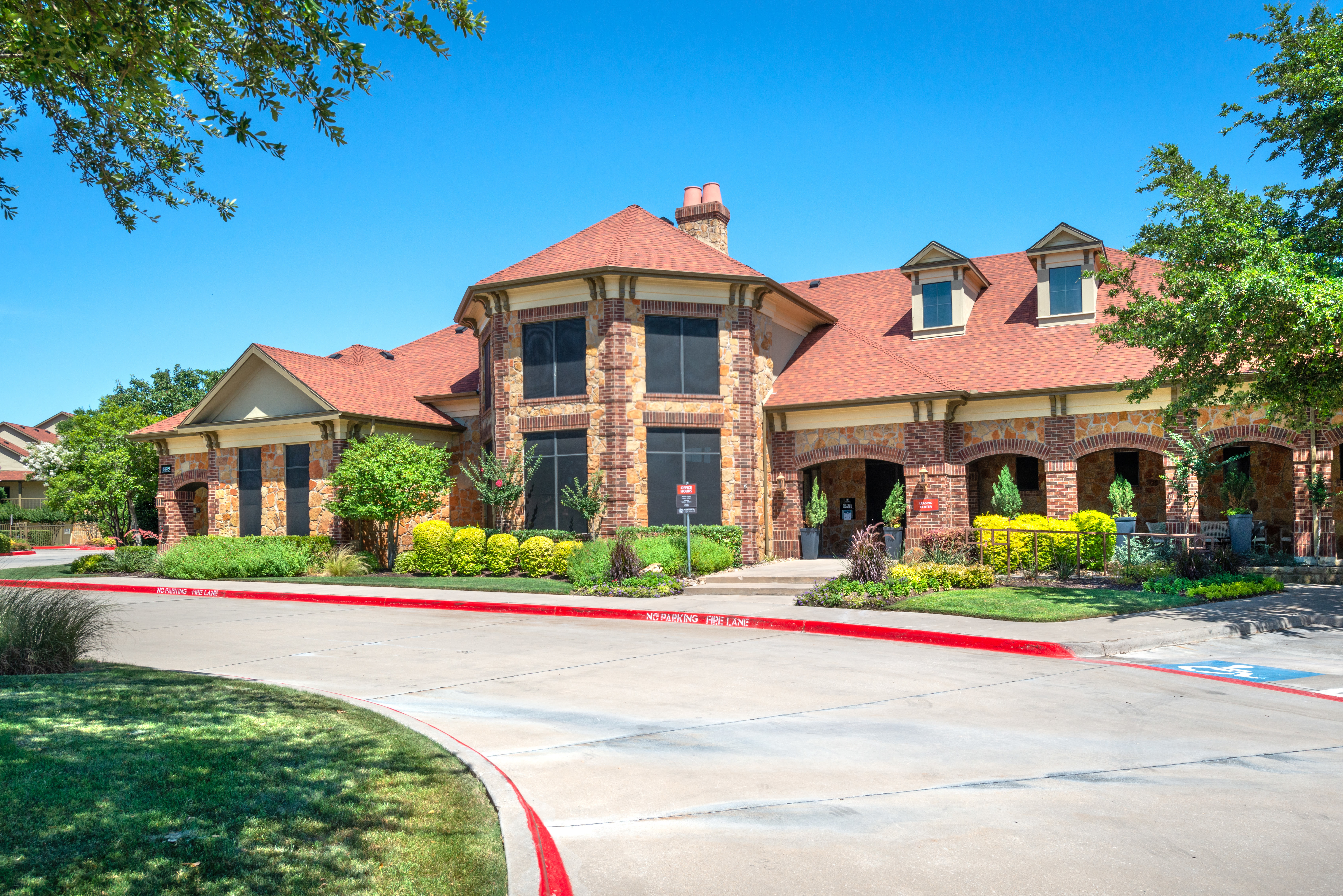 Well-maintained landscaping outside the clubhouse at Olympus Team Ranch in Benbrook, Texas