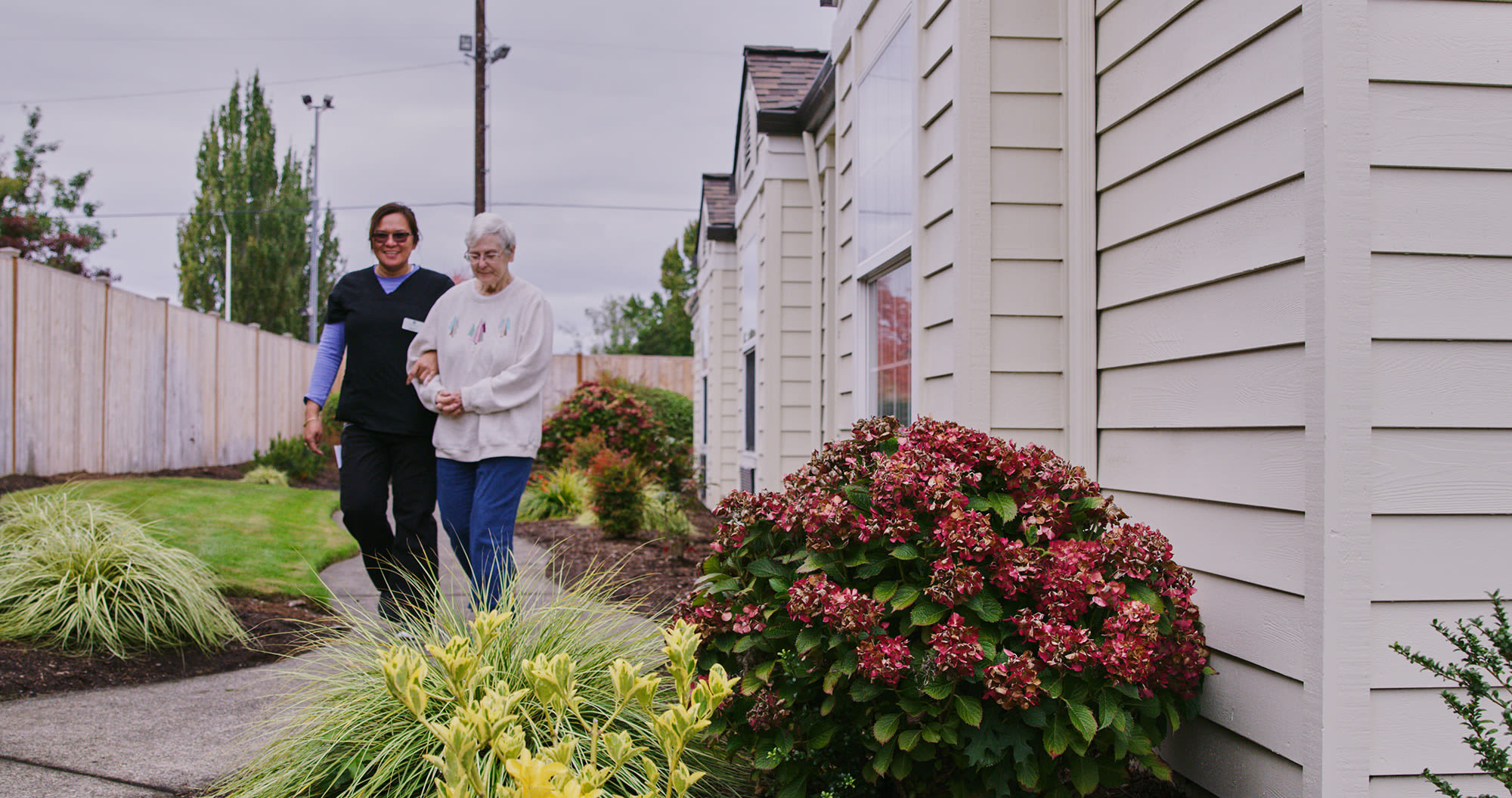 resident and a caretaker walking outside at Sweetbriar Villa in Springfield, Oregon