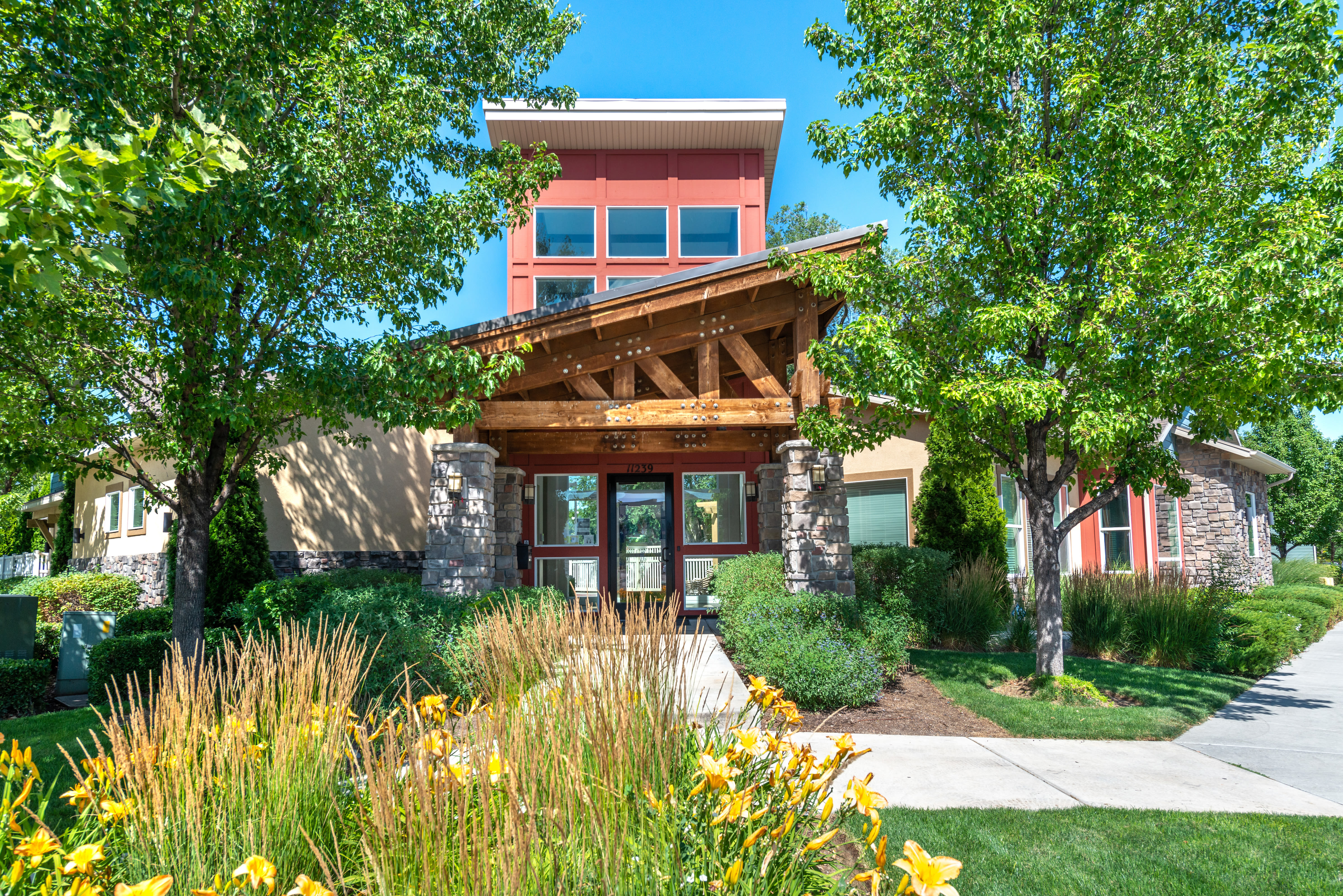 Clubhouse exterior with well tended landscaping at Olympus at the District in South Jordan, Utah
