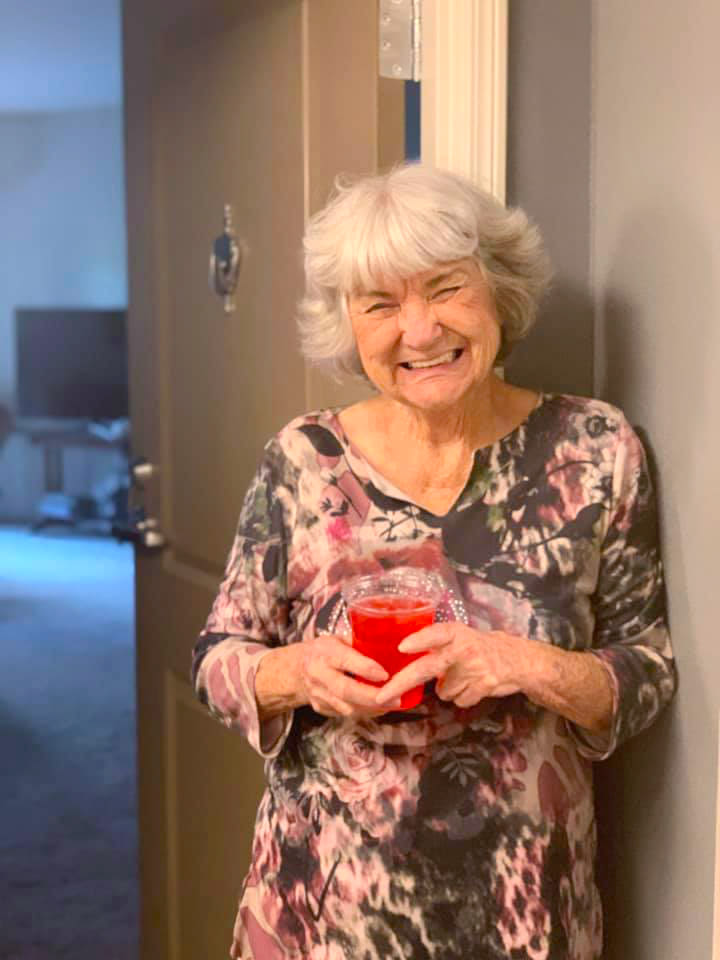 Resident standing in her doorway holding a drink at Oxford Villa Active Senior Apartments in Wichita, Kansas