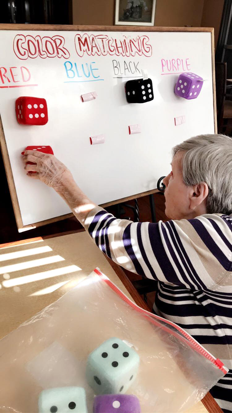 Resident playing a color matching game at Oxford Glen Memory Care at Sachse in Sachse, Texas