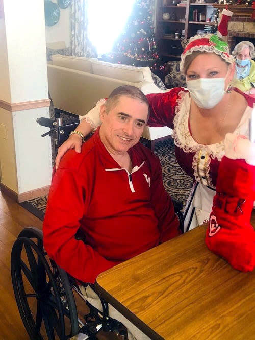 Resident receiving a stocking from a caretaker at Ashbrook Village in Duncan, Oklahoma
