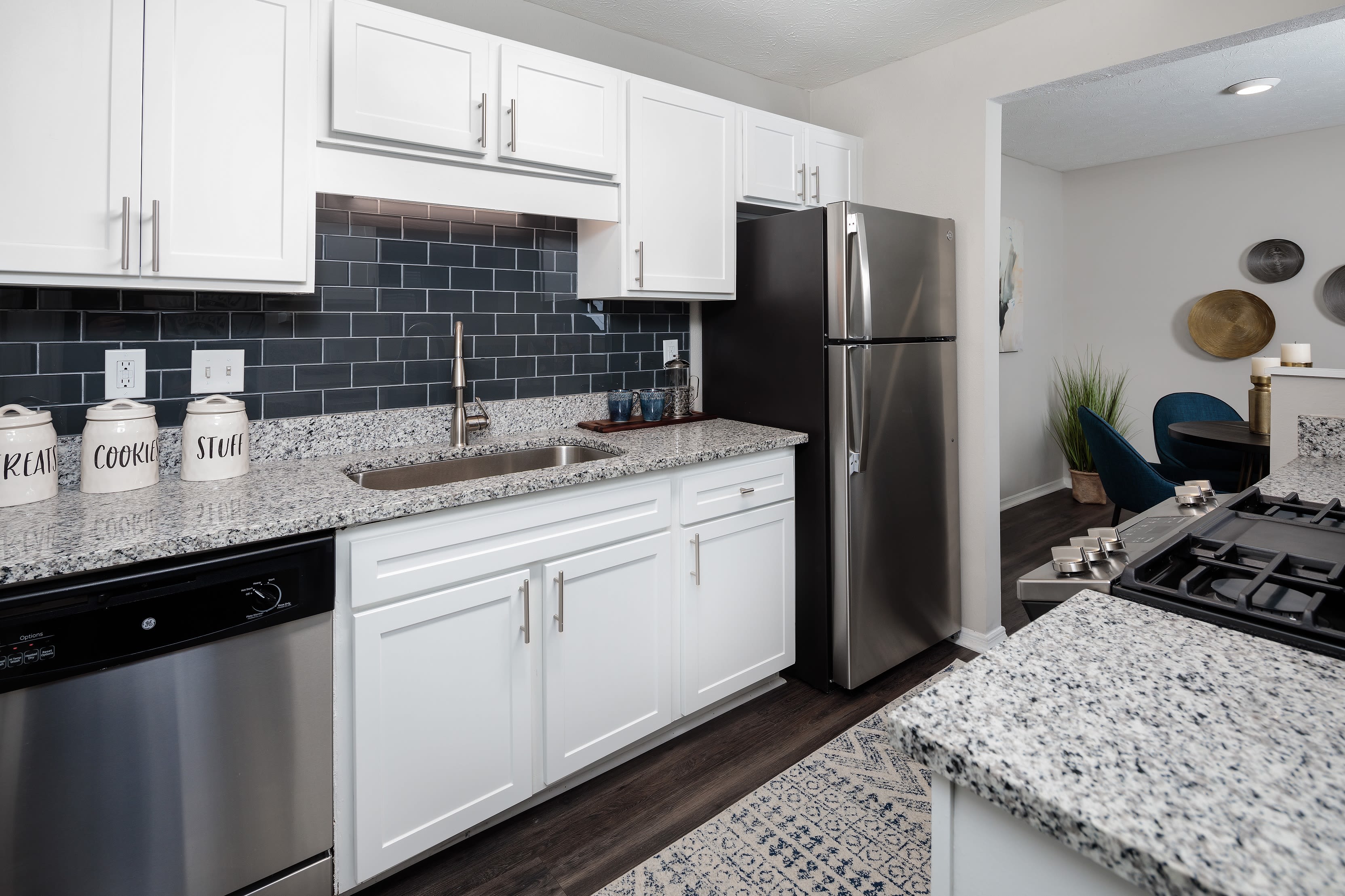 Model home's gourmet kitchen with a subway tile backsplash and granite countertops at The Bentley at Marietta in Marietta, Georgia