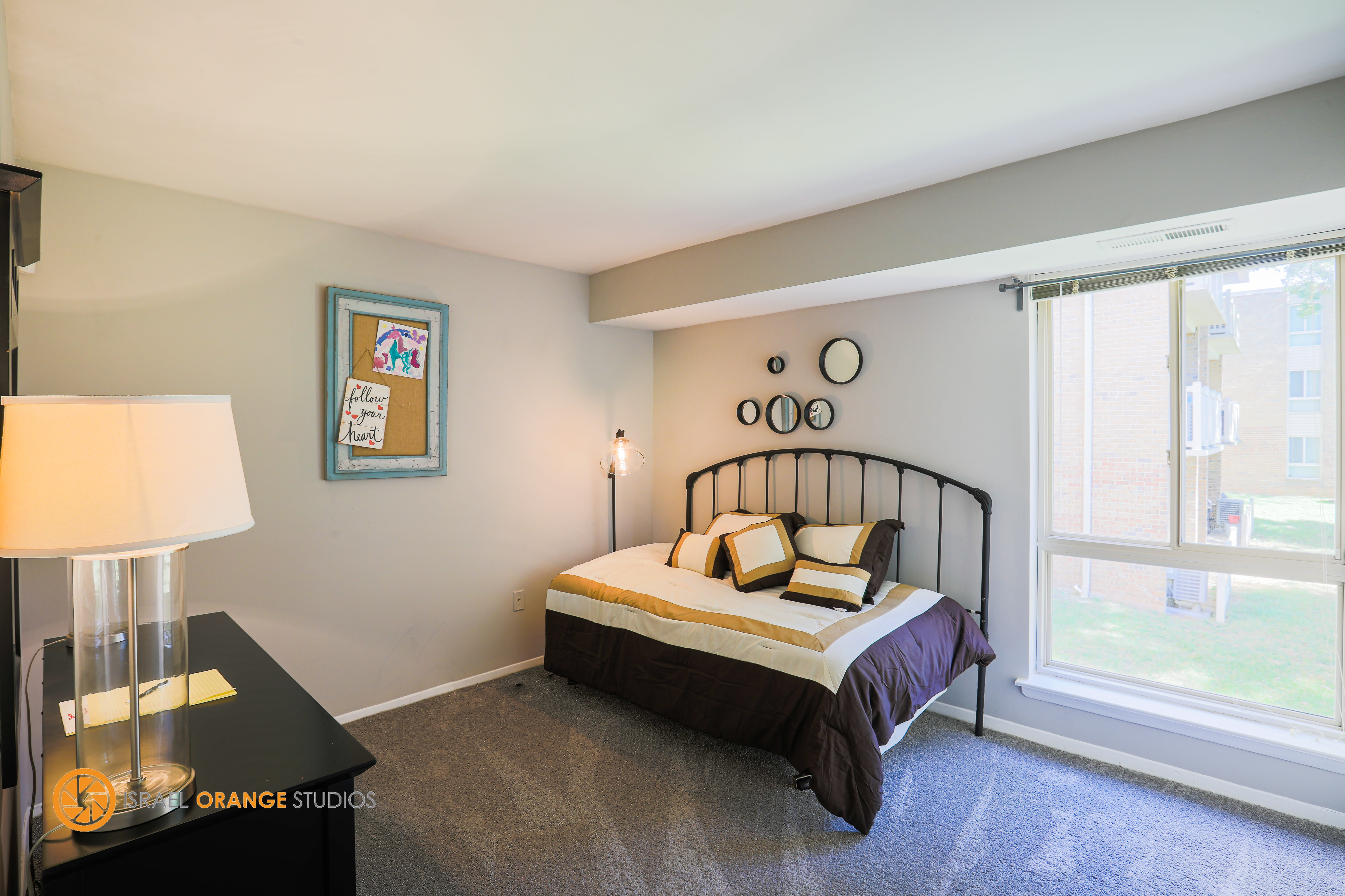 Bedroom next to a large window at The Glendale Residence in Lanham, Maryland